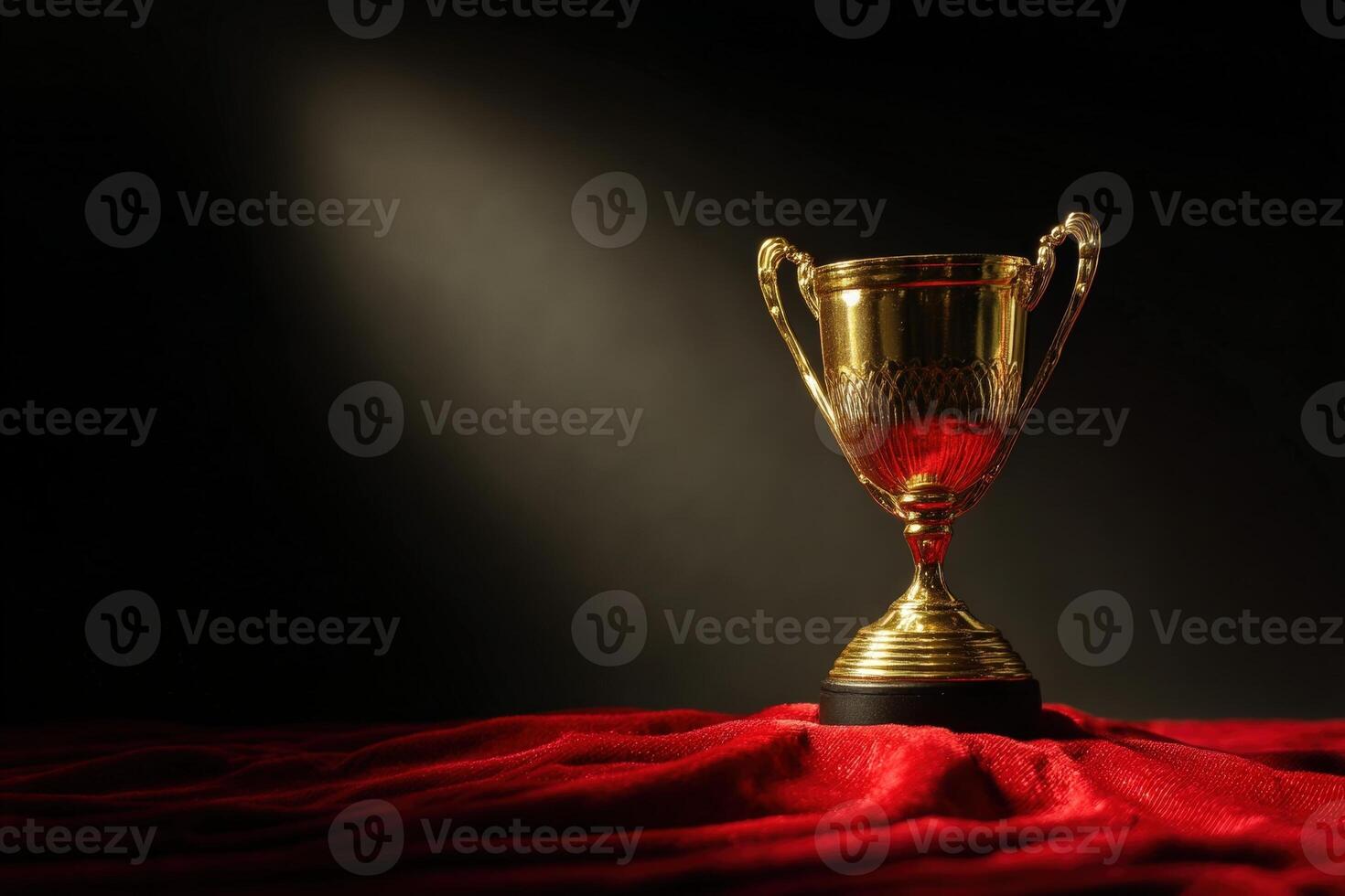 Golden trophy cup with ornate handles sits on shiny red cloth under spotlight, symbolizing achievement and excellence. This striking composition emphasizes luxury and prestige photo