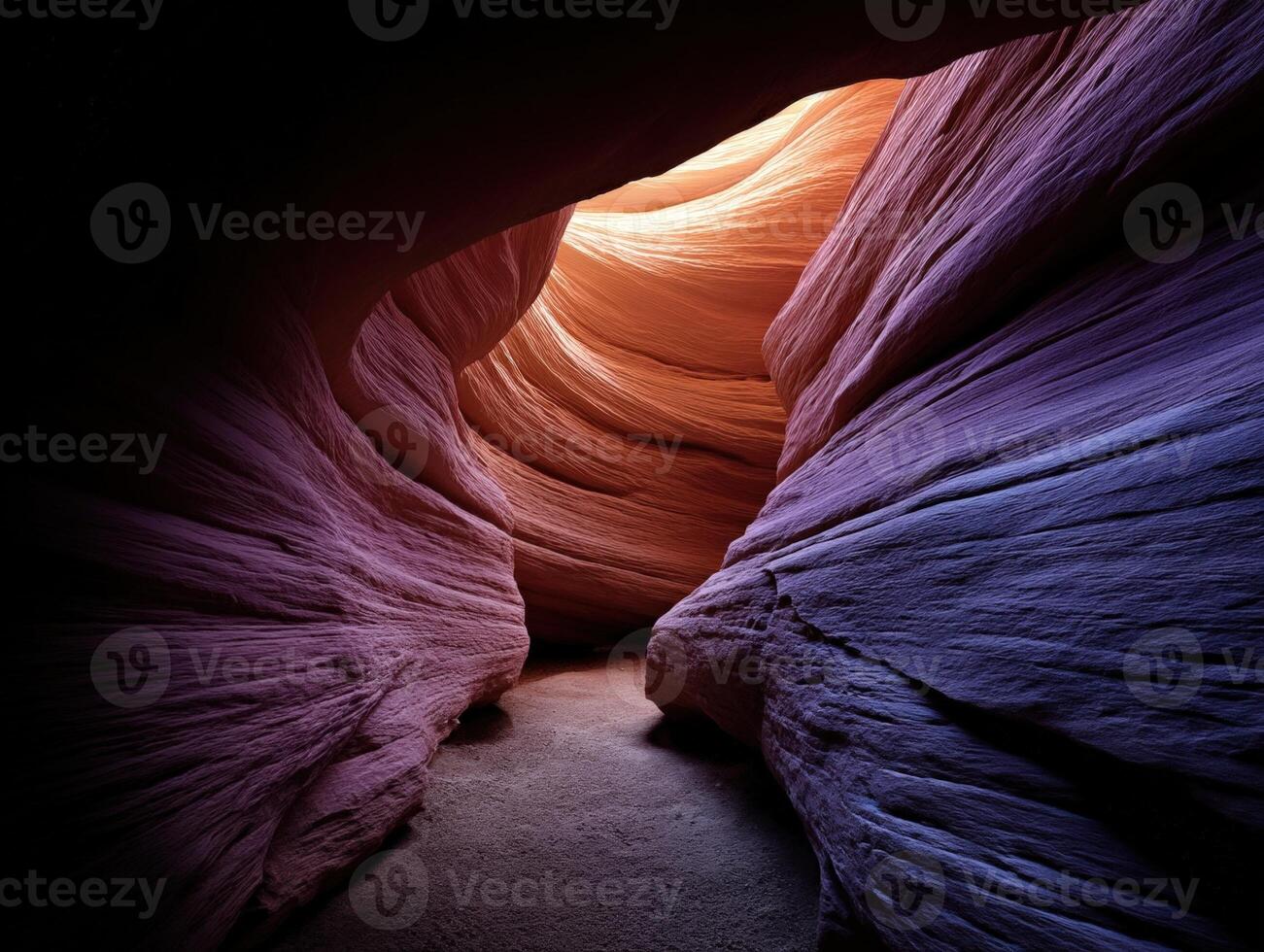 Curved rock formations create a tunnel-like path with vibrant hues of orange, purple, and pink. The light illuminates the textured walls, creating a dramatic interplay of shadows and highlights photo