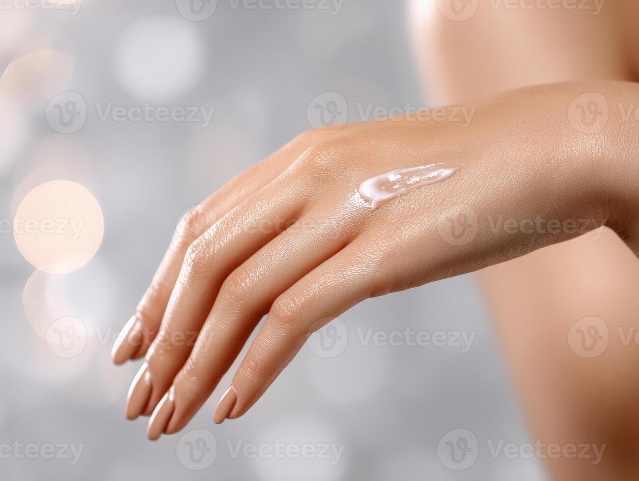 Elegant hand with cream applied softly on top, showcasing smooth skin and manicured nails against a soft, defocused bokeh background. Light reflects gently, emphasizing moisture photo
