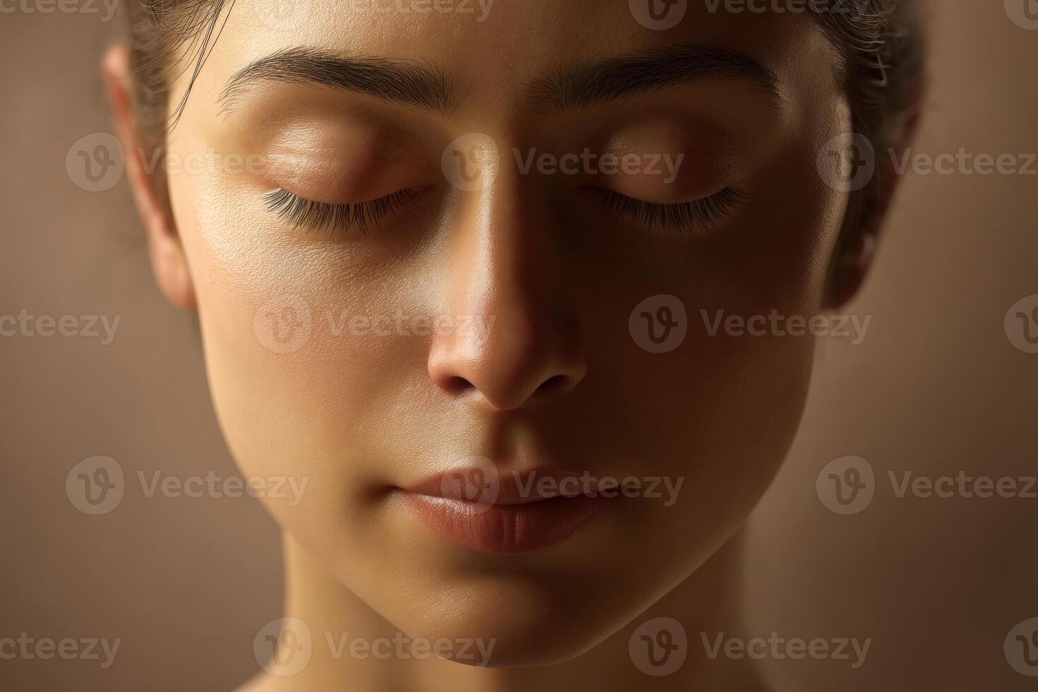 Peaceful expression of a person with closed eyes, gentle lighting on serene face creating soft shadows. The skin is smooth and luminous, emphasizing calmness and tranquility photo