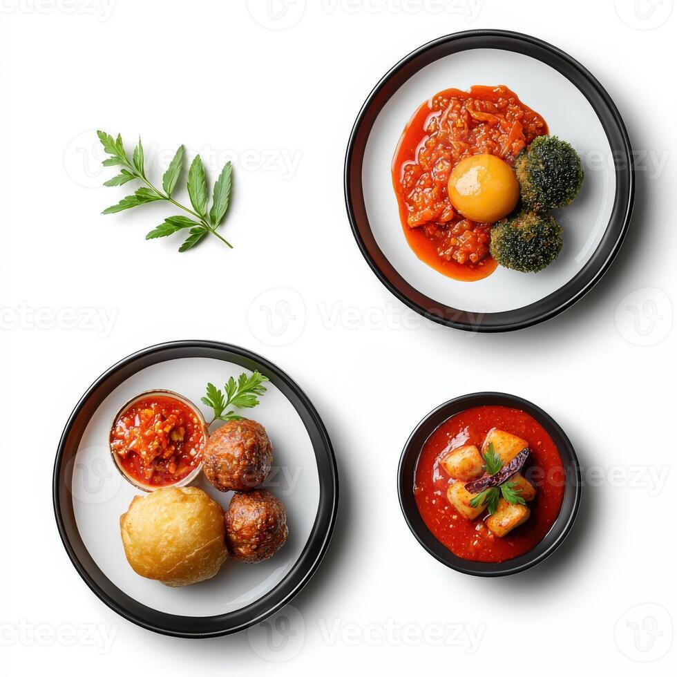 Three plates with food on them, including a meatball, a vegetable and a tomato photo