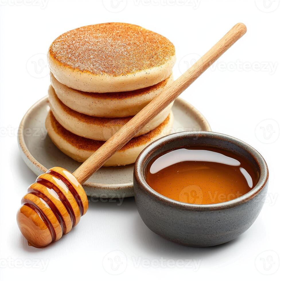 Stack of pancakes with honey and wooden spoon on white background photo