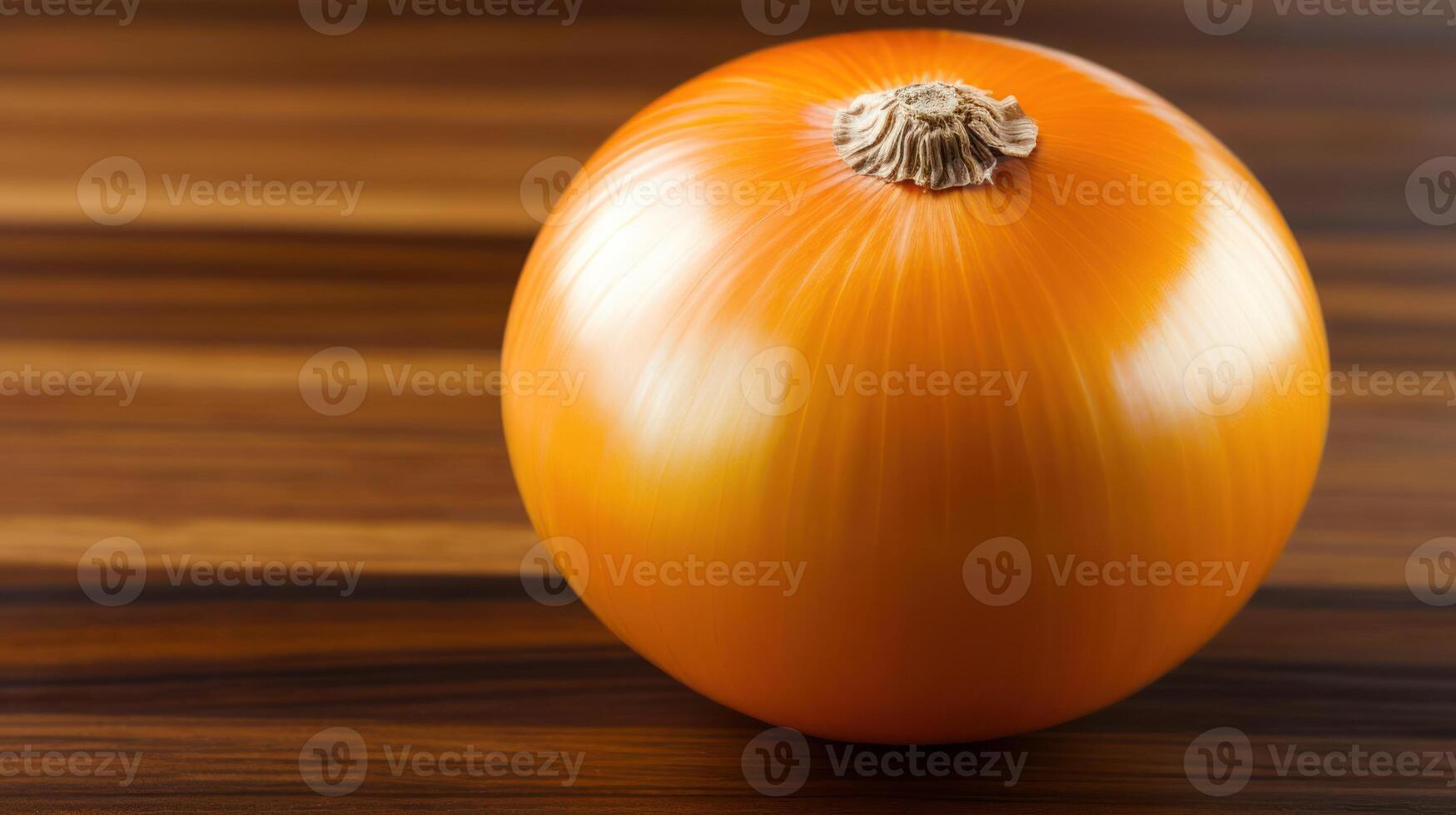 A vibrant yellow onion sits on a wooden surface. photo