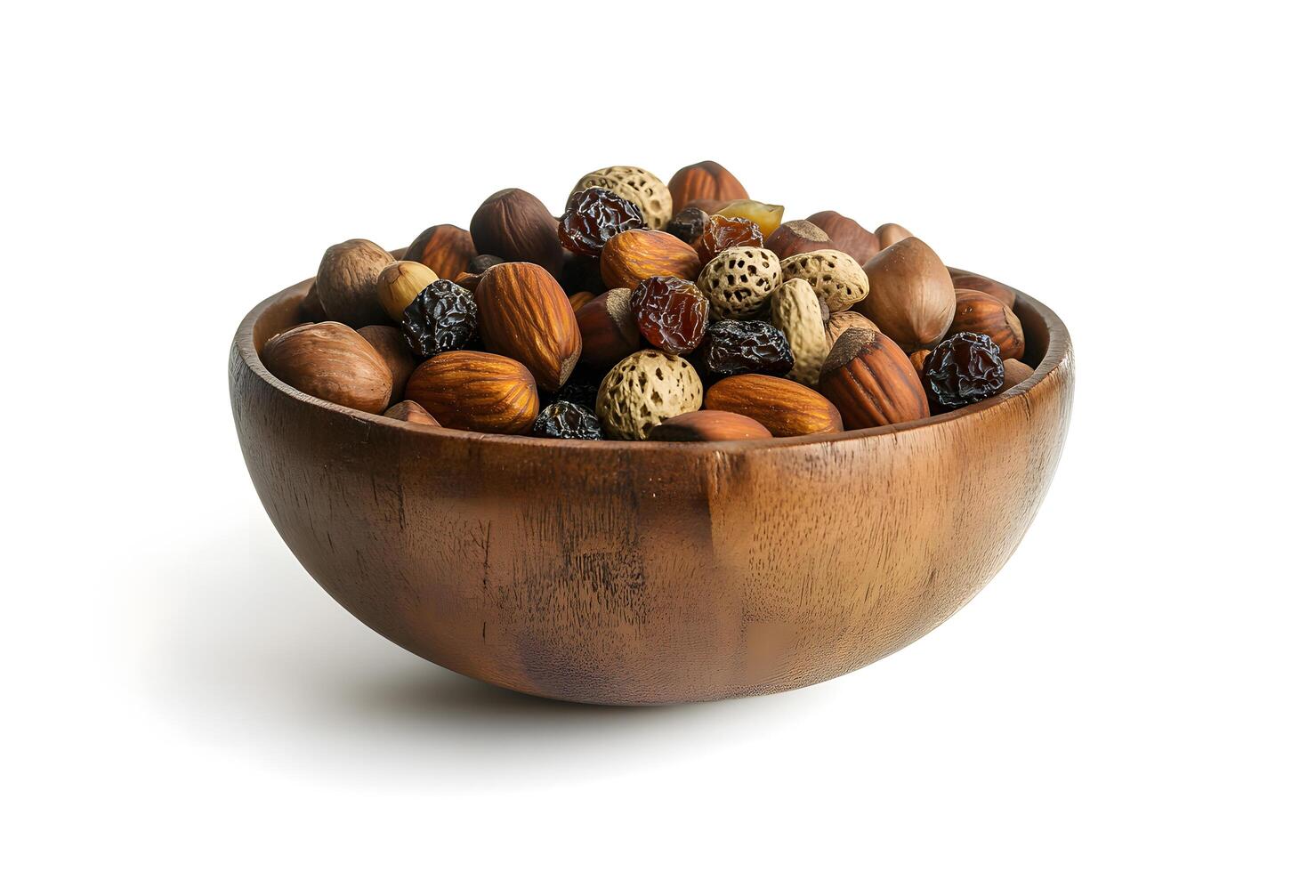 Assorted nuts including almonds, hazelnuts, and raisins fill a rustic wooden bowl beautifully against white photo