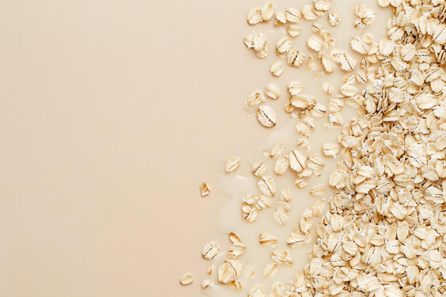 Beige background shows a portion of dry oatmeal alongside liquid oats, spilling across it photo