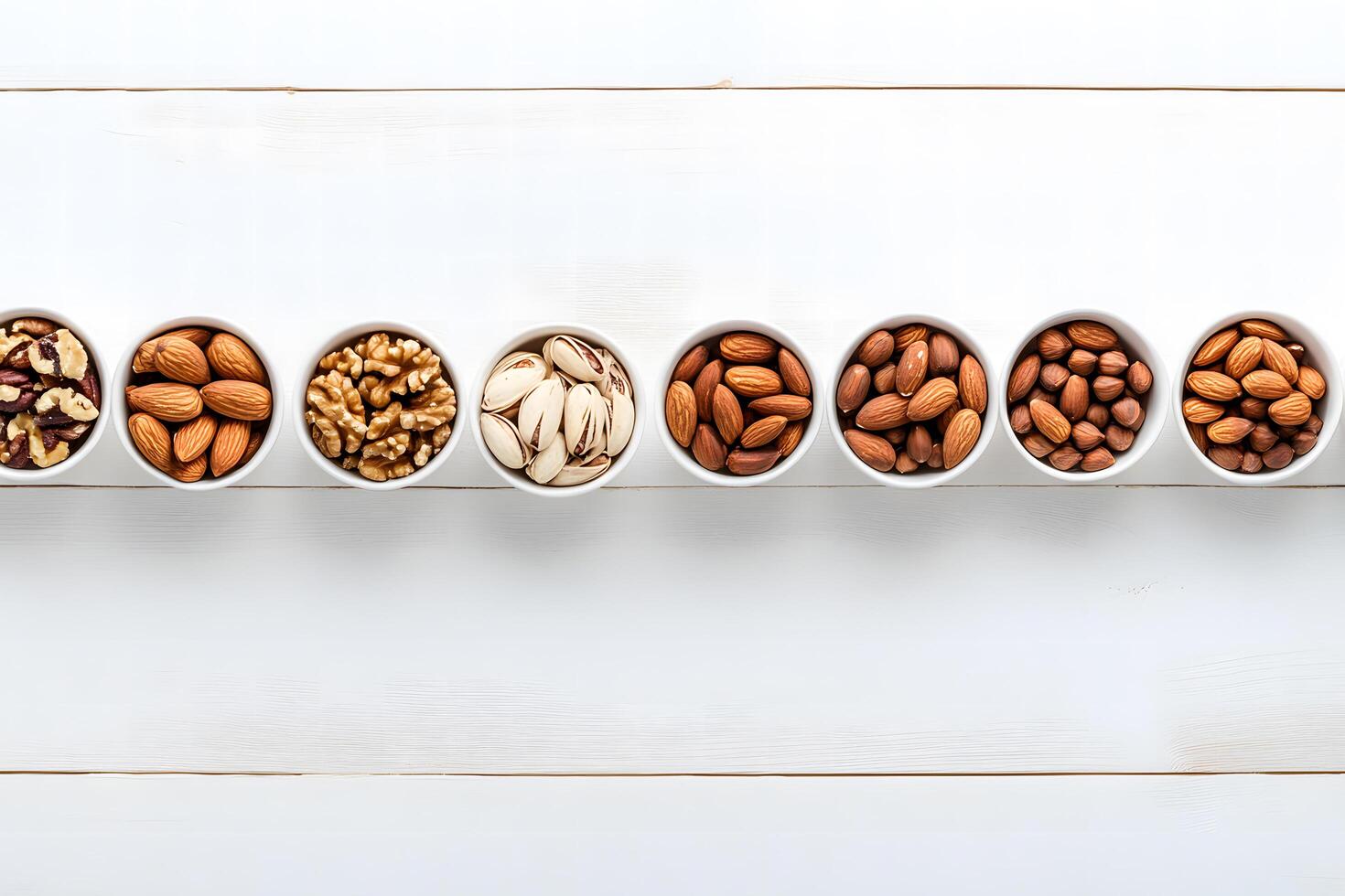 Bowls of assorted nuts beautifully arranged on a white wooden background offers a nutritious choice photo
