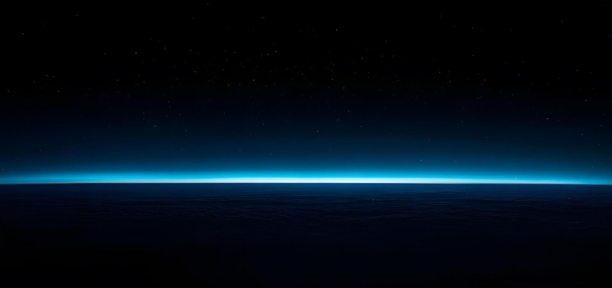 Bright blue atmosphere above dark textured surface meets a star speckled night sky photo
