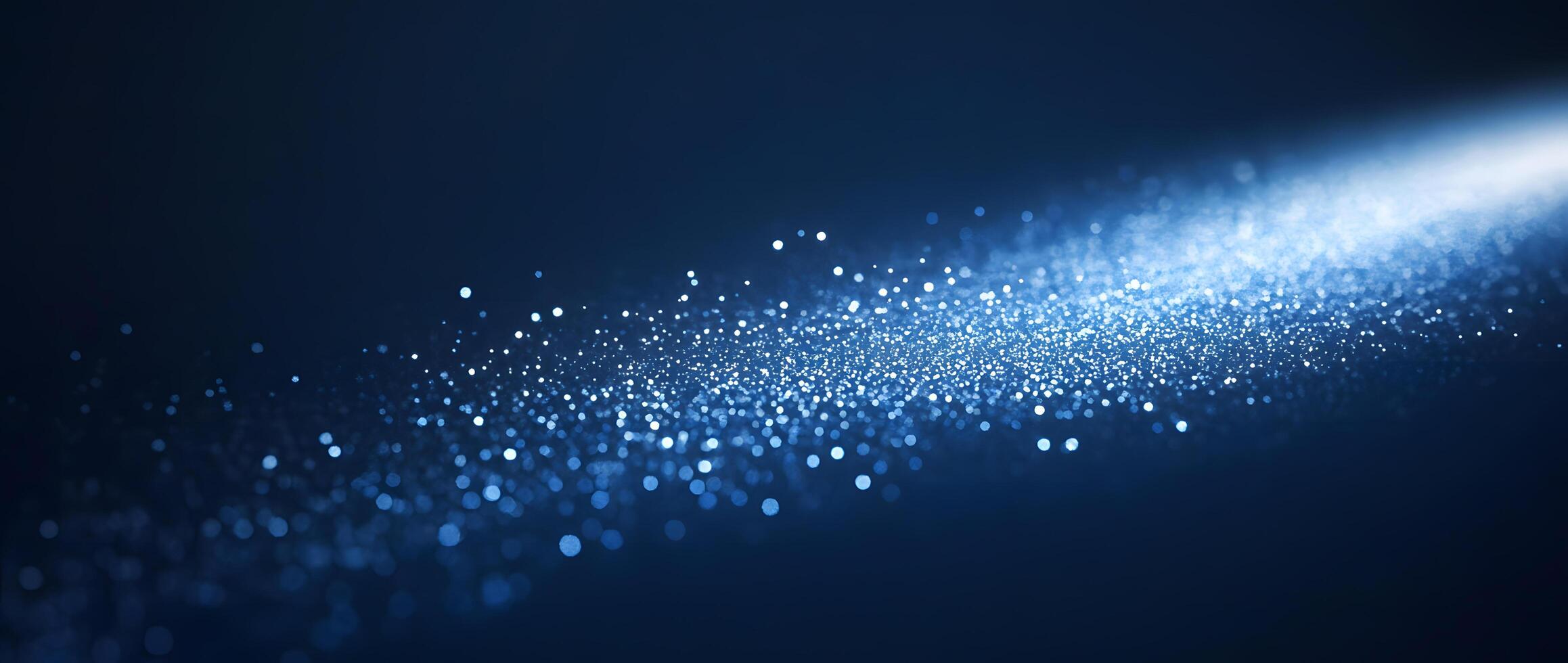 Bright, ethereal blue light cascades across a dark backdrop, illuminating sparkling particles across its surface photo