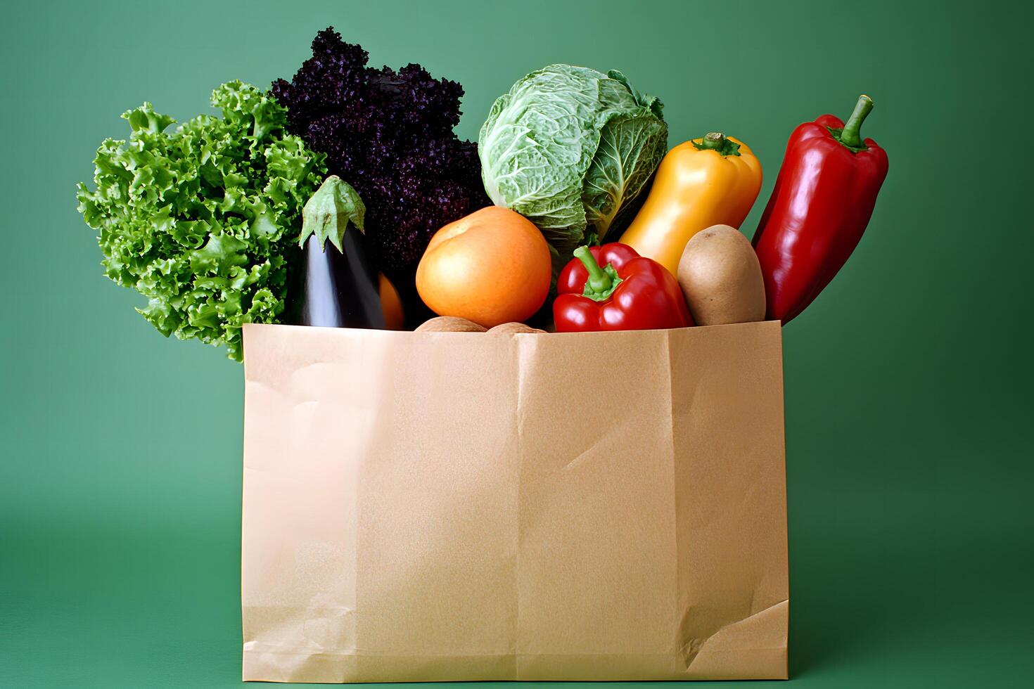 Fresh assorted vegetables are overflowing from a brown paper bag on green backdrop photo