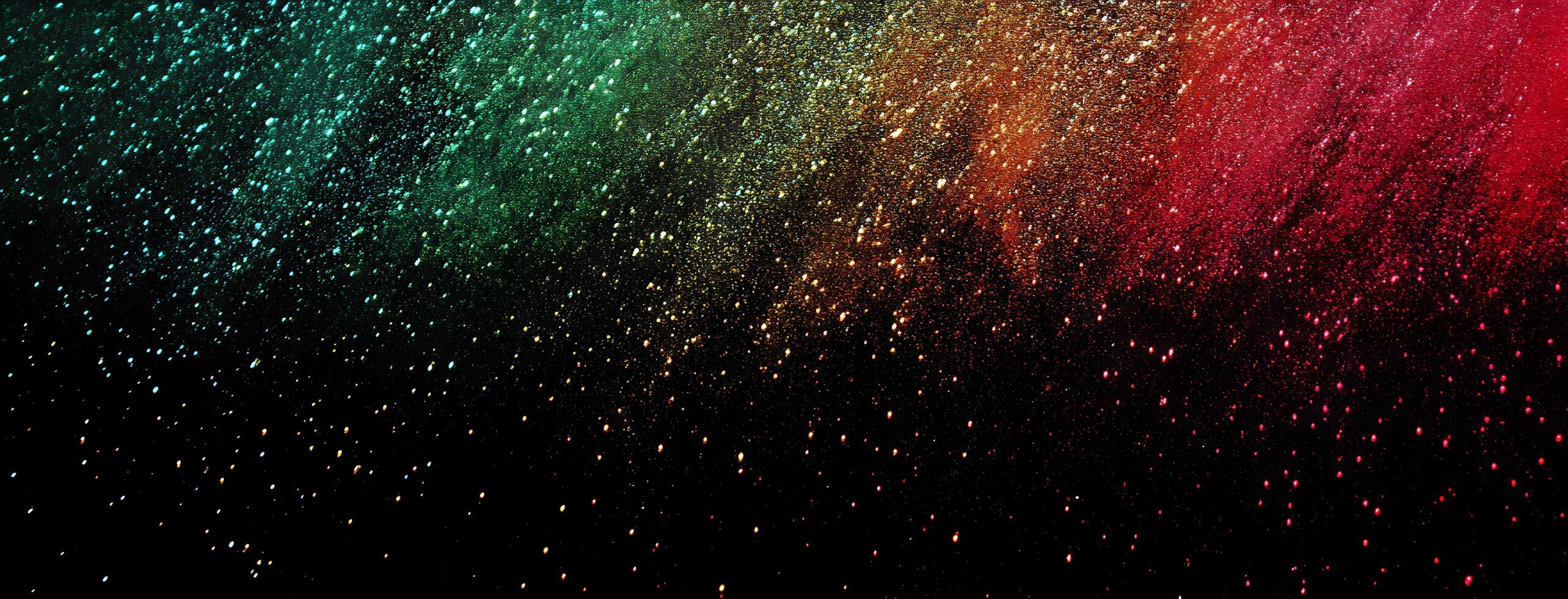 Multicolored powder explosion cascades gracefully against the dark backdrop, creating a vibrant and captivating spectacle photo