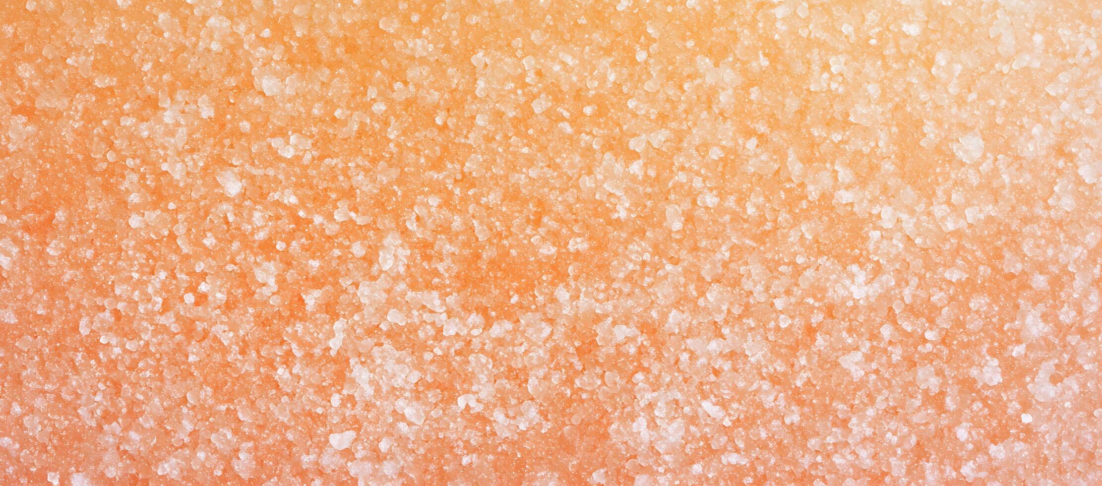 Peachcolored salt crystals are scattered across the entire frame, creating a textured surface photo