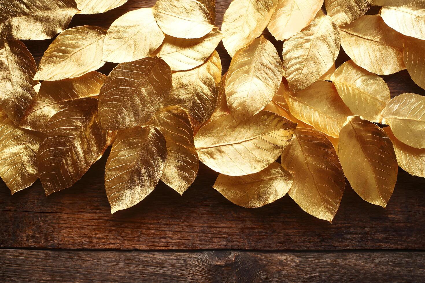 Shiny gold leaves are artfully arranged atop dark stained rustic wood, forming an elegant border photo
