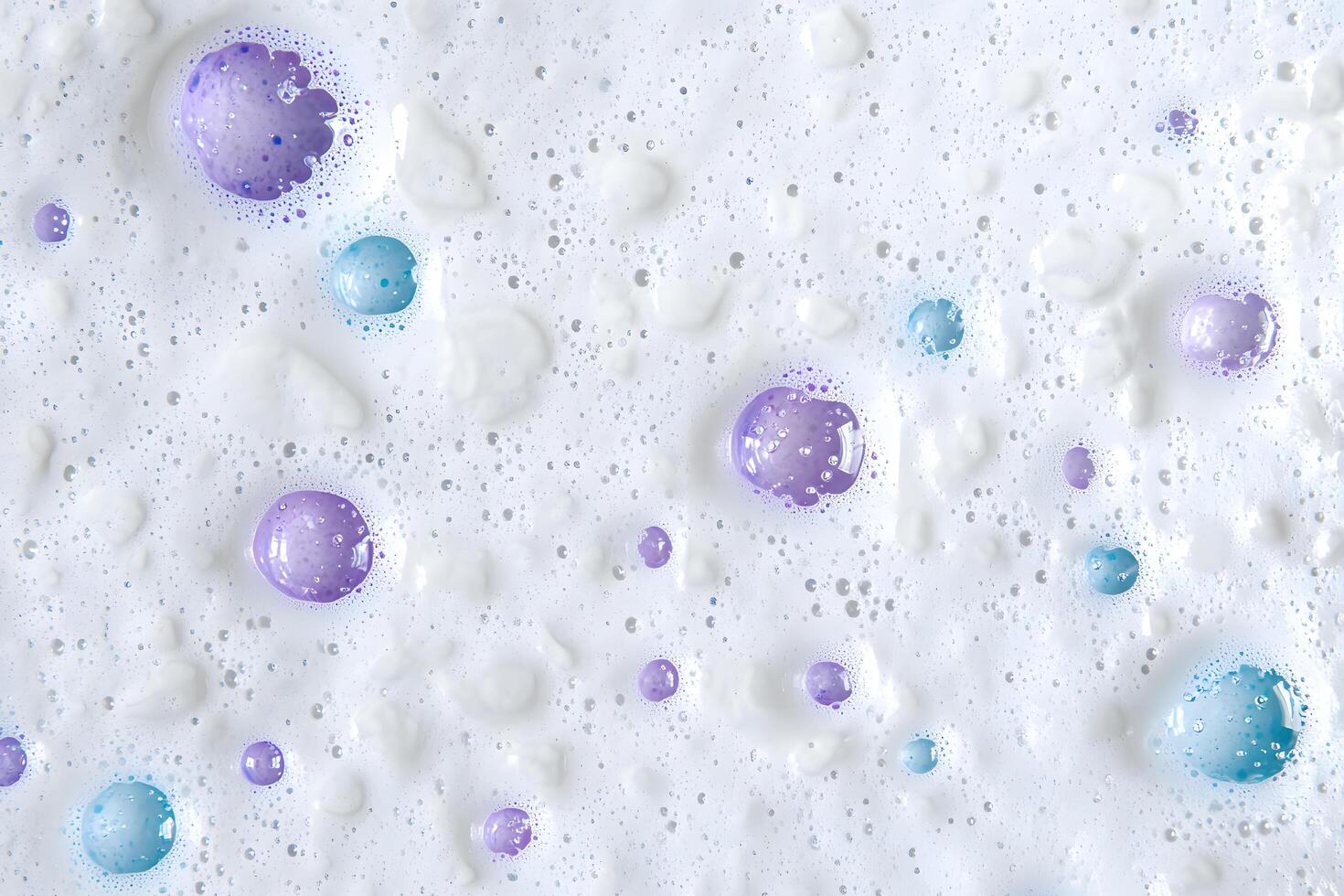 Shiny pastel spheres float among light white foam and tiny water droplets create texture photo