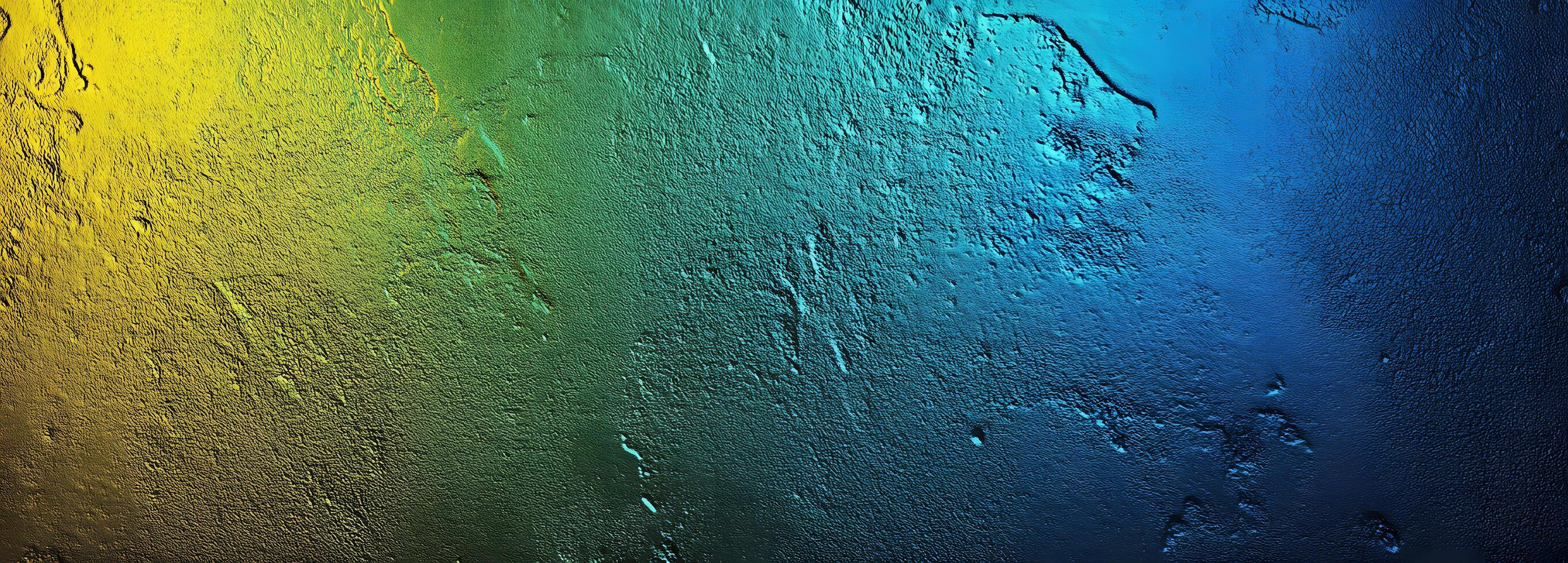 Textured surface with a vivid gradient transitions from yellow to green, blue, and deeper indigo photo