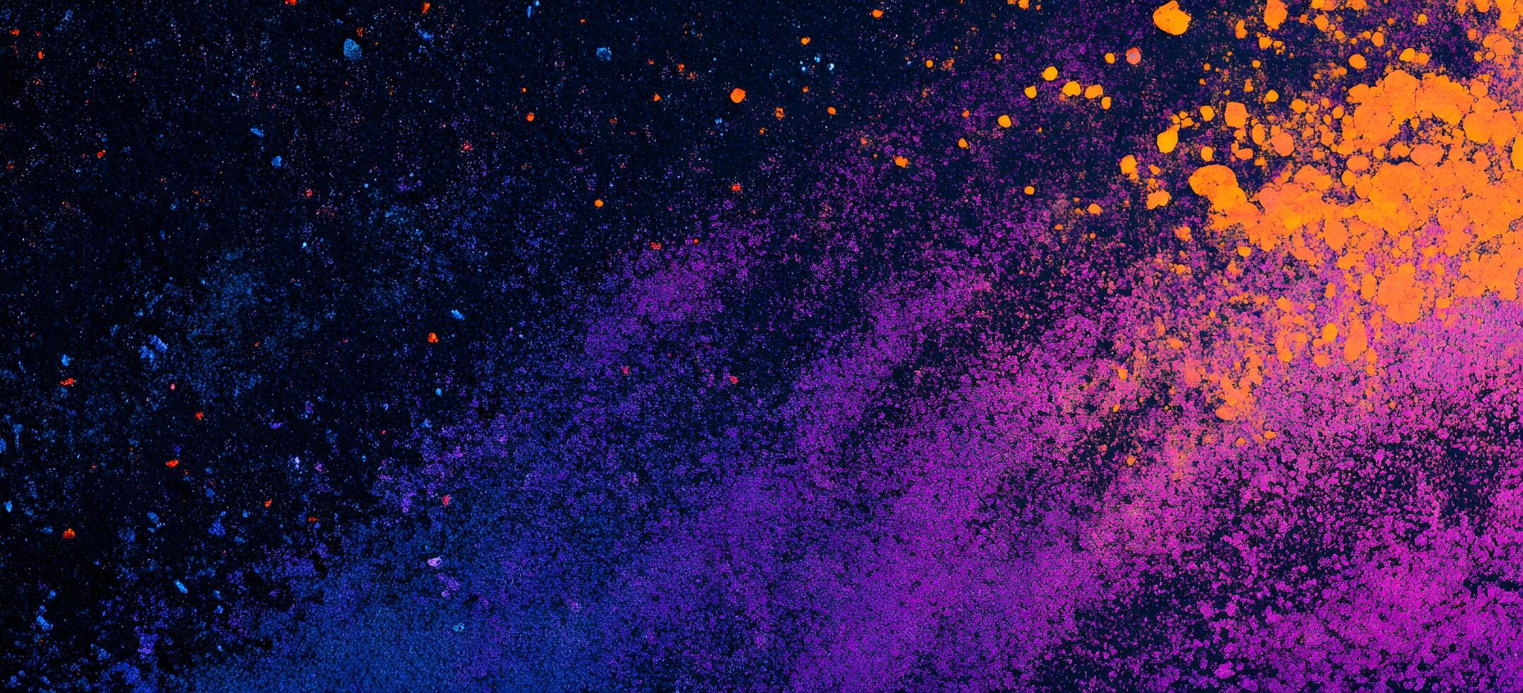 Vibrant orange and purple powder explodes across a dark backdrop creating an eyecatching texture photo