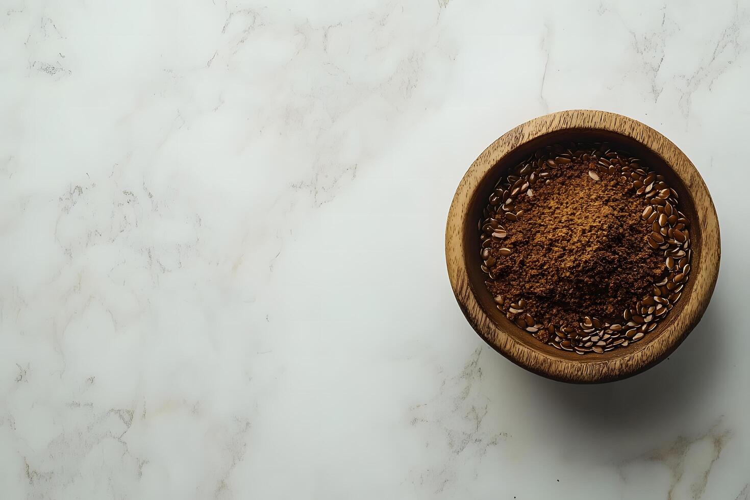 Whole and milled flaxseeds are presented inside a rustic wooden bowl on marble background photo