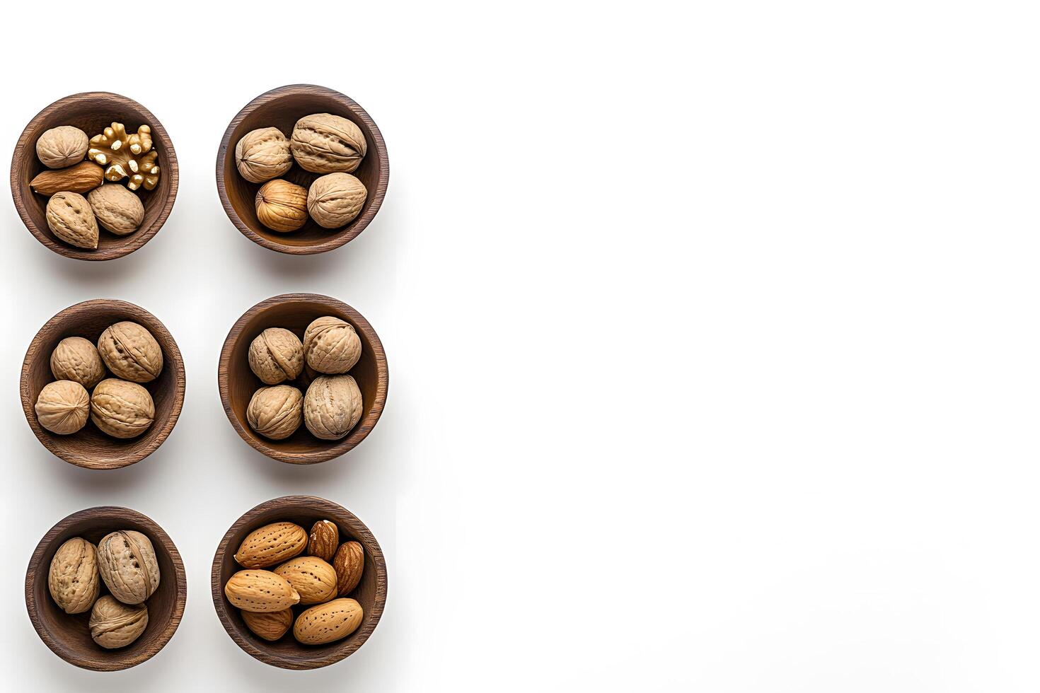 Wooden bowls filled with almonds and walnuts are arranged elegantly on a white surface photo