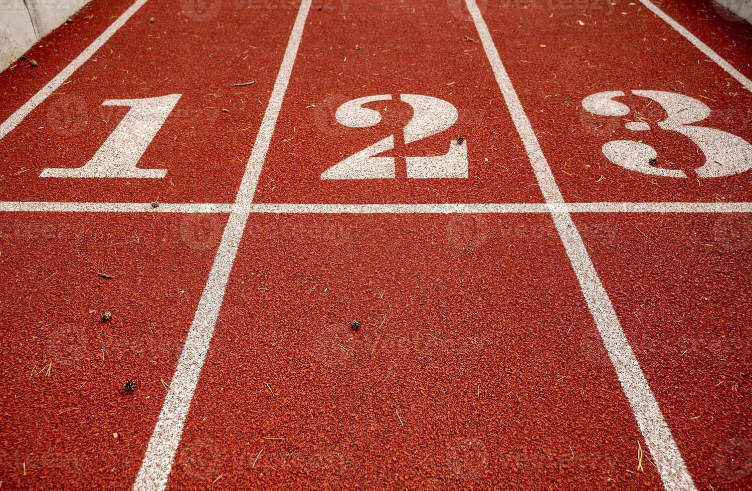 Red running track in stadium, with numbers at the start one, two, three, the running track is deep red. Sport recreation. Helthy lifestyle concept. High quality photo