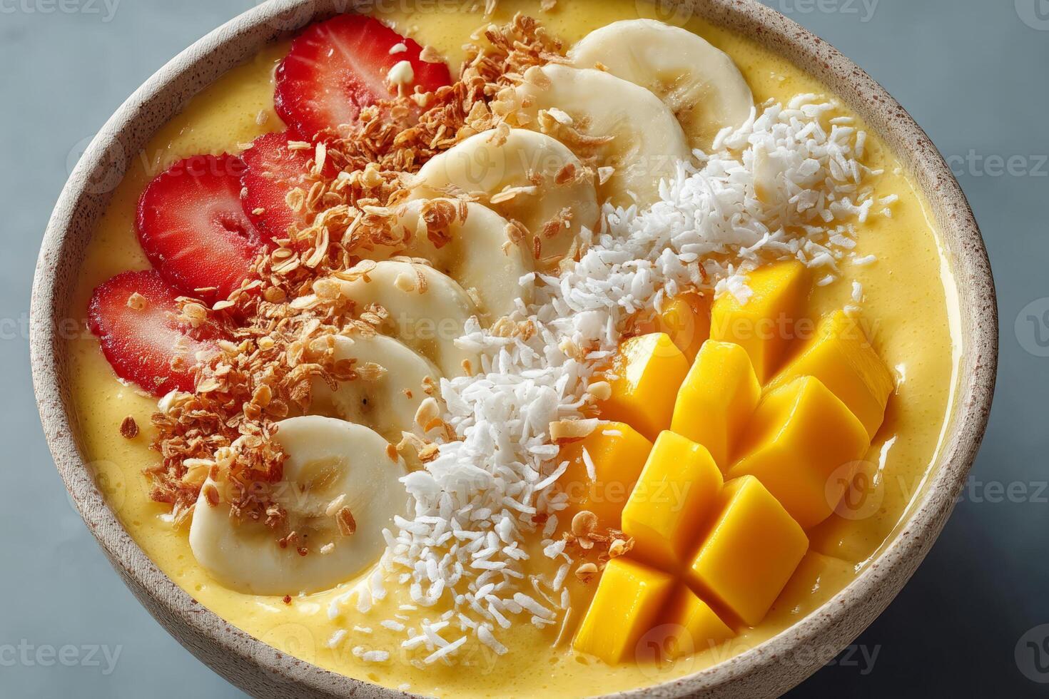 Tropical smoothie bowl with strawberries, banana and mango photo