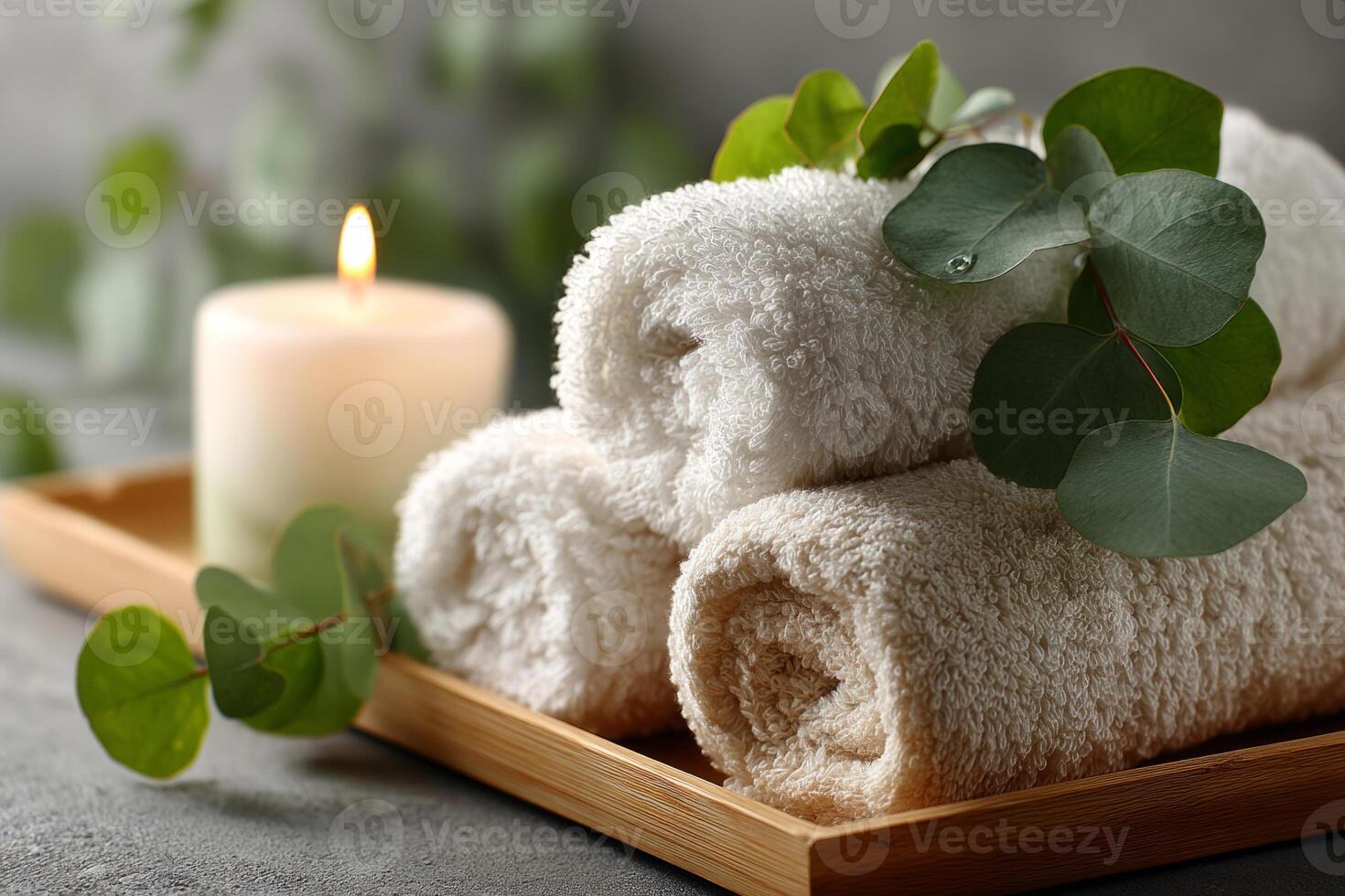 Rolled spa towels with eucalyptus and candle photo