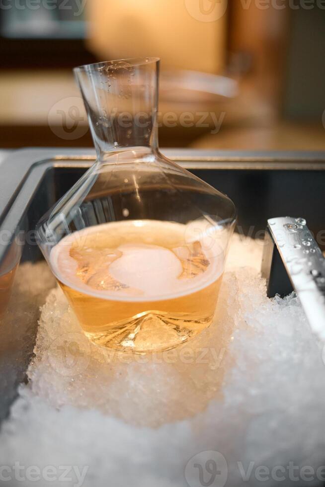 Decanter of rose champagne is cooled in a niche with ice in the restaurant, local lighting, wine cabinet, bubbles photo