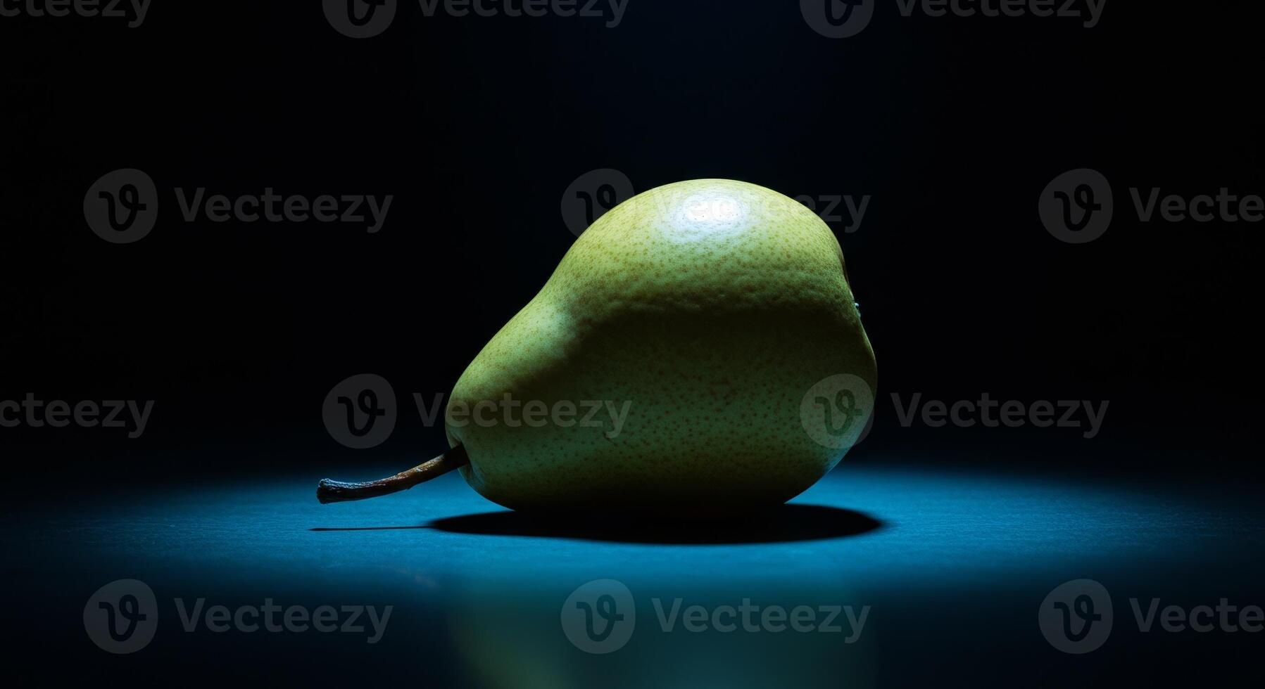 A pear is shown in the dark with a light photo