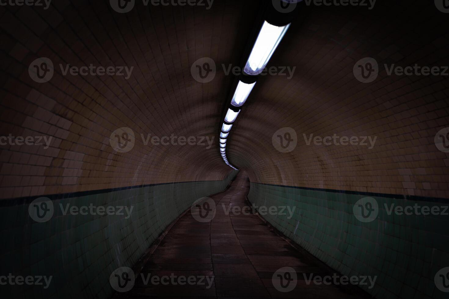 Empty pedestrian tunnel with artificial lights and tiled walls photo