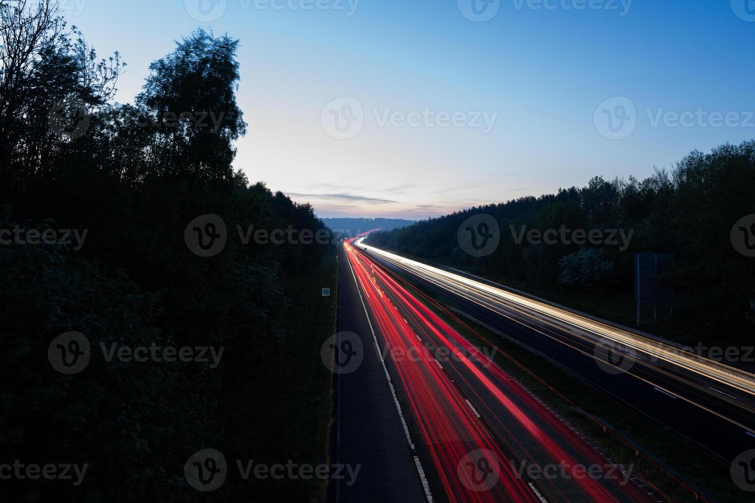Highway with light trails at dusk showing commuting traffic photo