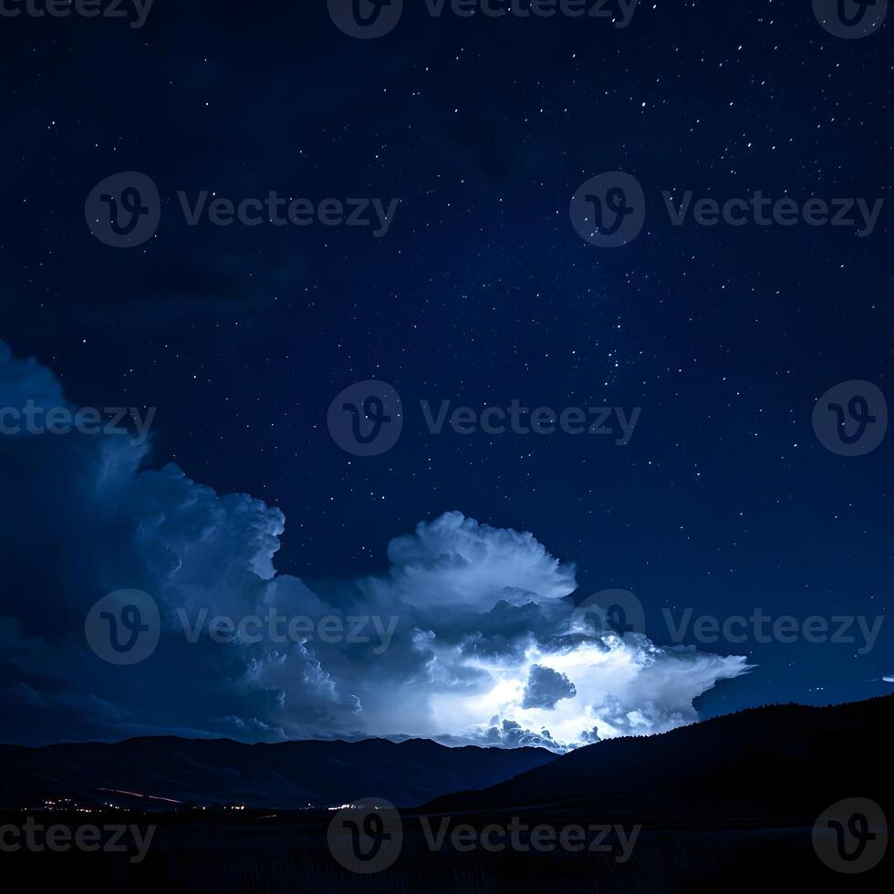 Lightning illuminating night sky with stars and clouds over mountains photo