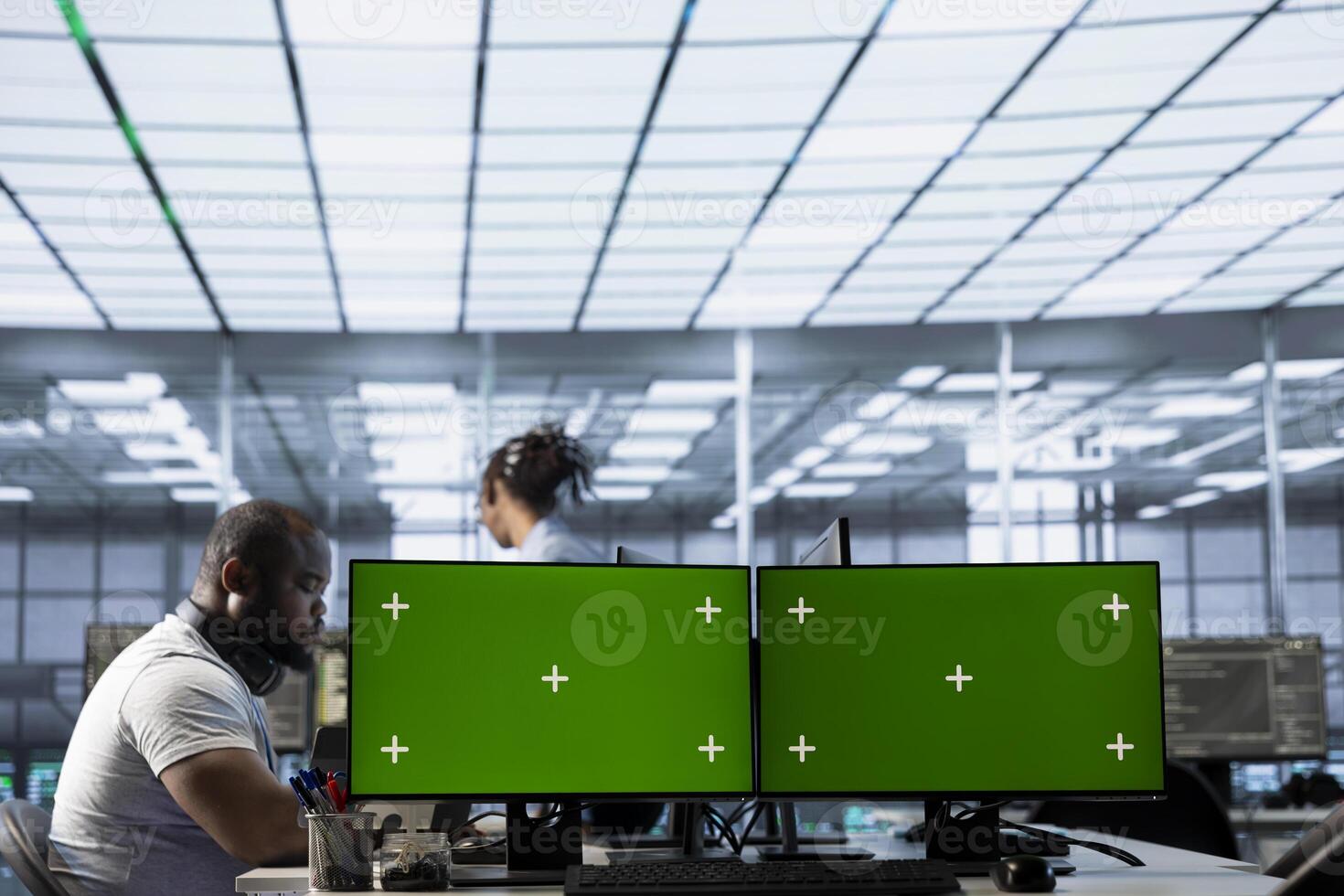 Data center employees using isolated screen multi monitor PC setup to write disaster recovery plans ensuring minimal downtime. Server farm engineers use chroma key computer to monitor performance photo