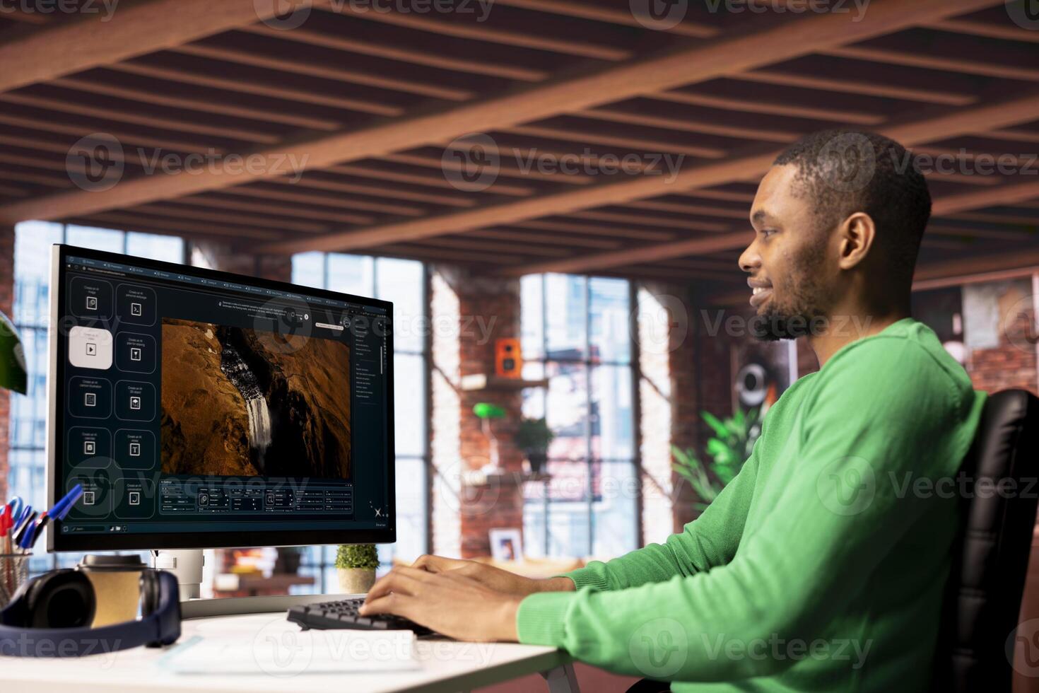 Smiling man using AI program turning text prompt into videos, pleased by results. Joyous african american person interacting with text to artificial intelligence generative model photo