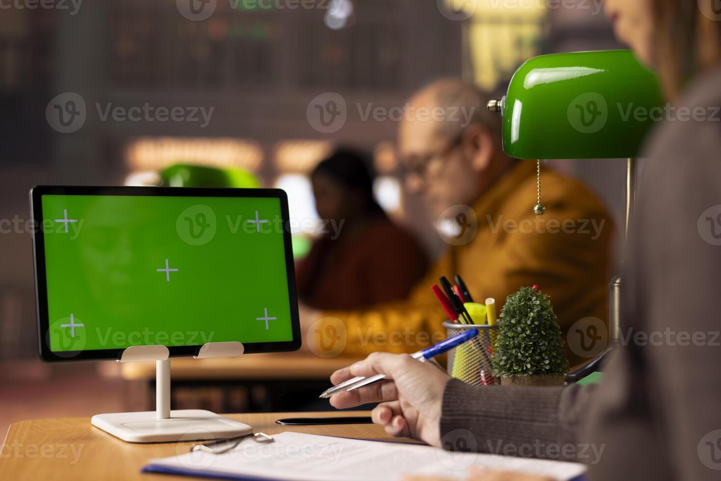 Woman student transcribing information from class notes next to mockup, collecting information to use as citations in her thesis paperwork. College scholar consulting the academic database. photo