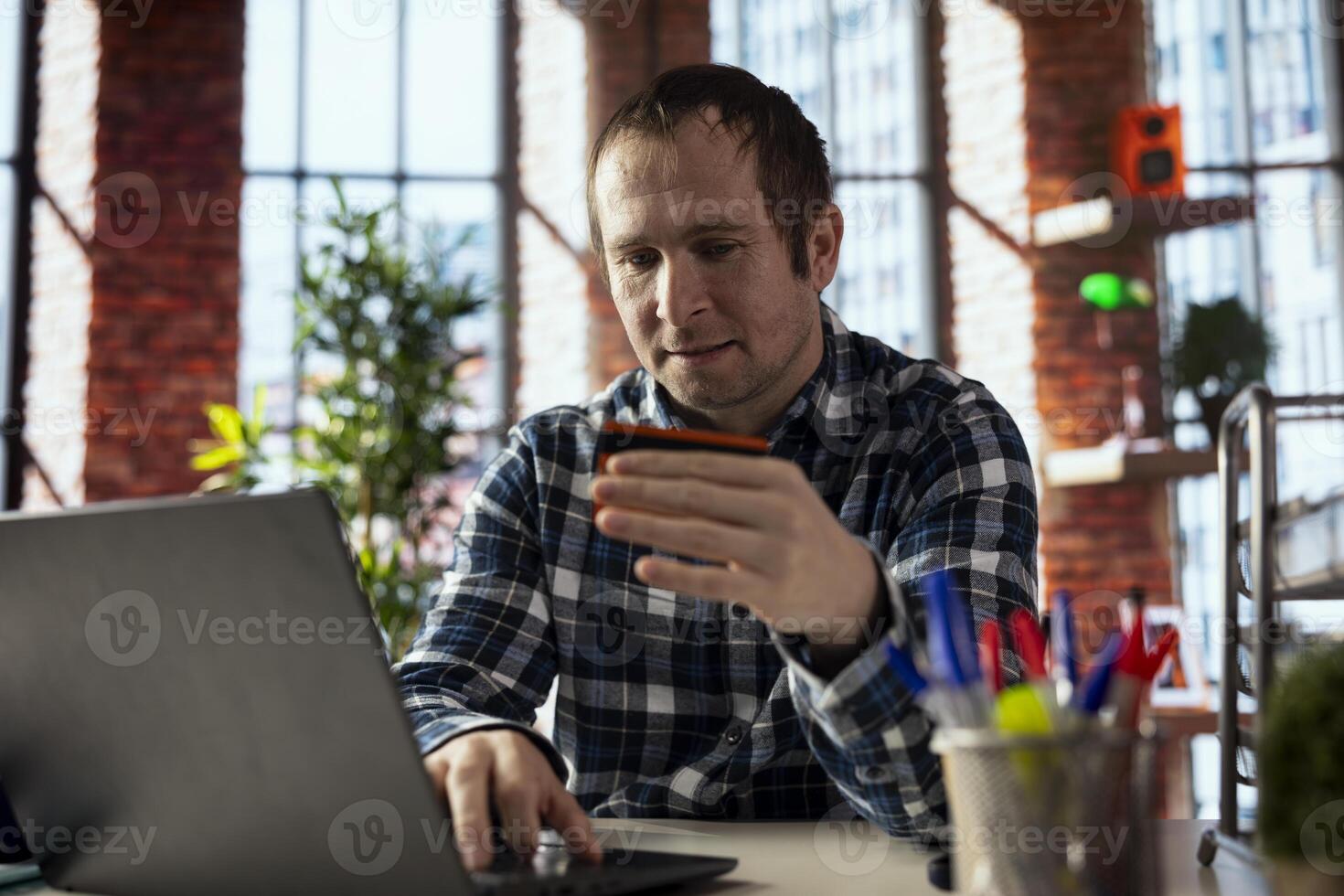 Man doing internet shopping, typing credit card information on laptop, placing items in cart, advancing through checkout steps. Person doing online transactions, adding payment method on website photo