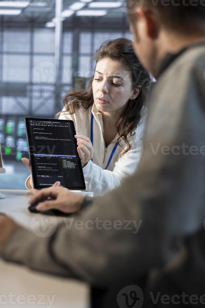 Team on engineers using tablet in data center, managing and optimizing IT infrastructure using network management skills. Server room coworkers upgrading gear with device, reducing operational costs photo