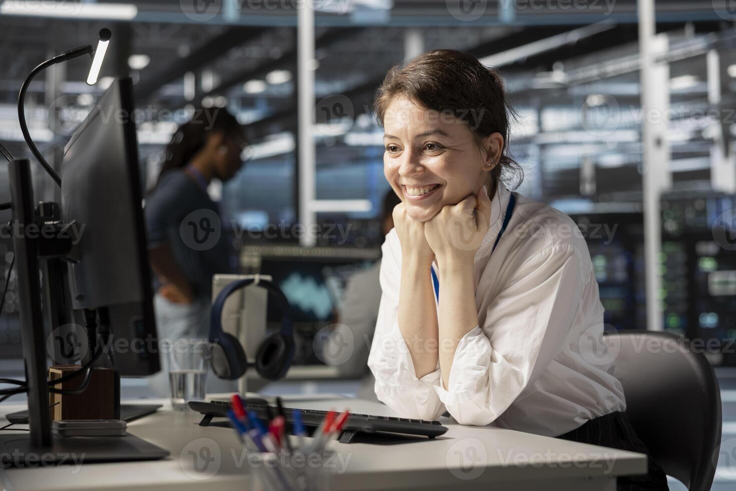 Jolly engineer in server hub satisfied by improved system efficiency metrics. Cheerful woman working in data center pleased by enhanced network infrastructure performance after finishing update photo