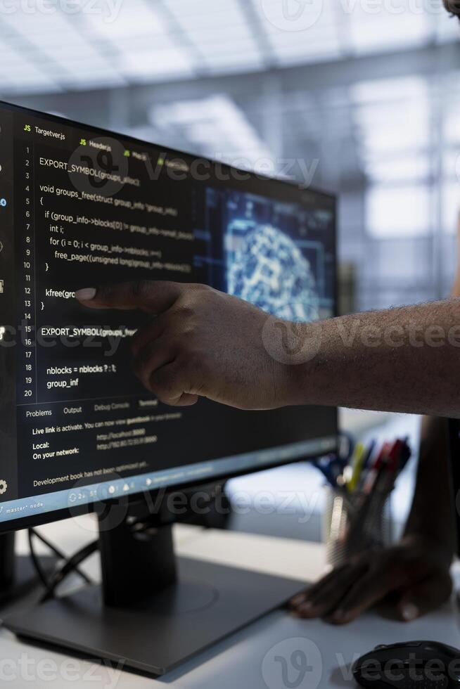System administrator using machine learning applications to optimize server farm operations. IT expert pointing to PC monitor, implementing server virtualization in data center facility photo