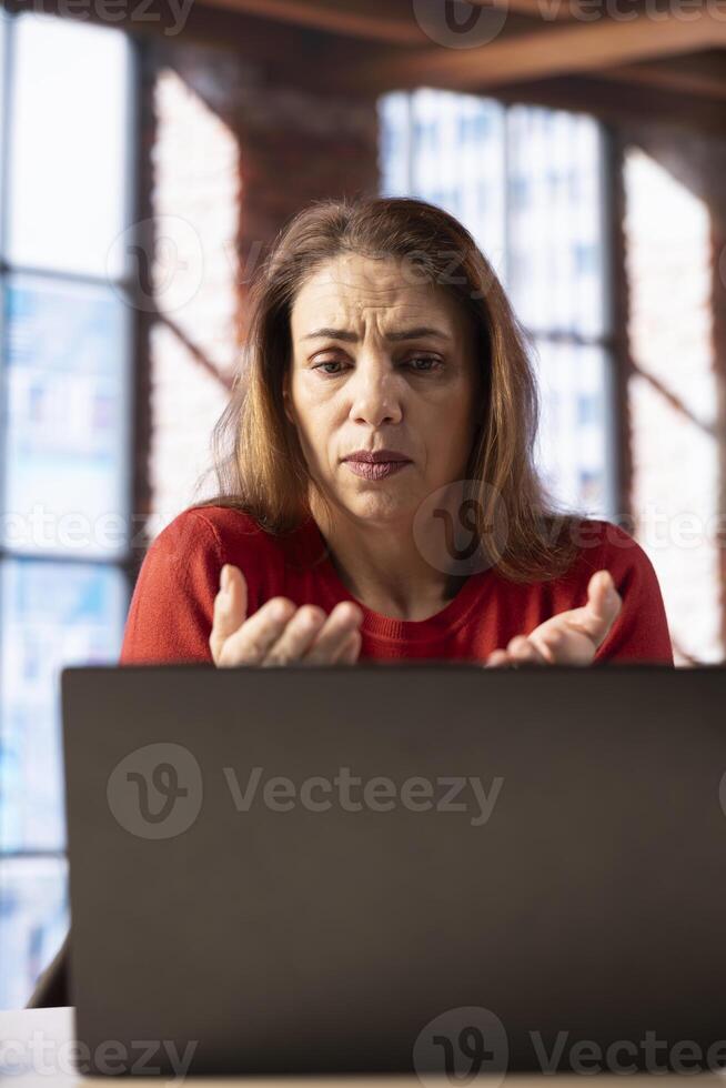 Mature student trying to learn a new language from her loft apartment, attending an online course lesson to develop her skills. Ambitious person solving exercises and tasks remotely. photo