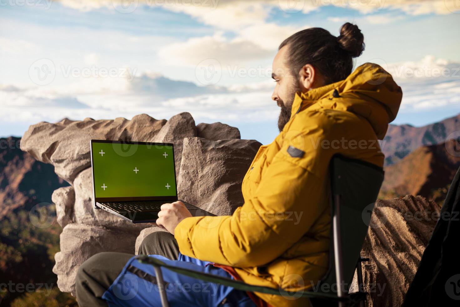 Pleased excited explorer enjoying the panoramic beauty with a green screen, admiring the rocky mountain range. Endless landscape symbolizing personal growth and mental clarity. Camera A. photo