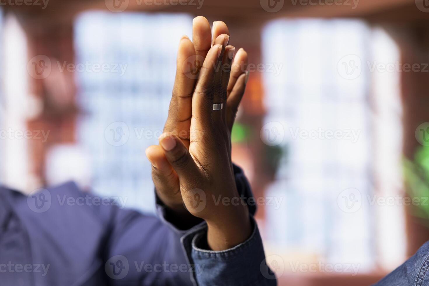 Black freelancing couple doing a high five to celebrate their achievement, completing tasks to ensure successful project. Young man and woman feeling pleased with their cooperation. Close up. photo