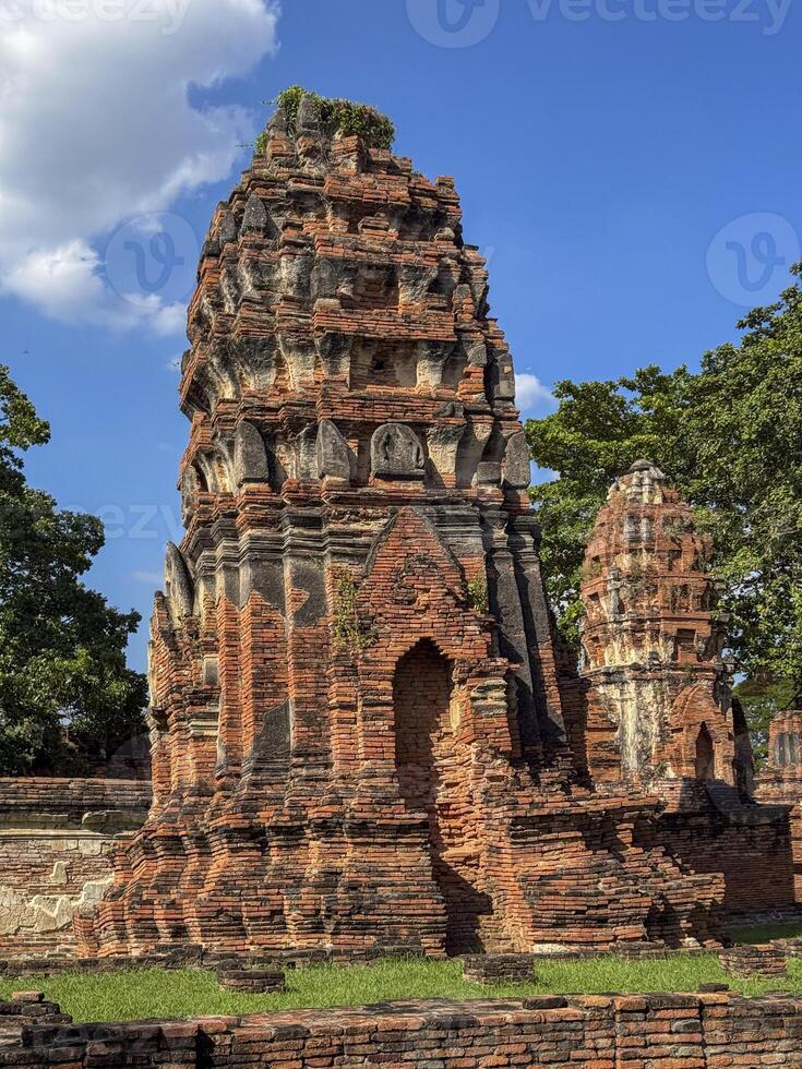 Stunning sunlit view of Wat Maha That traditional Buddhist temples, admiring ancient brick architecture at the famous Thailand landmark. Spiritual and cultural tourist attraction. photo