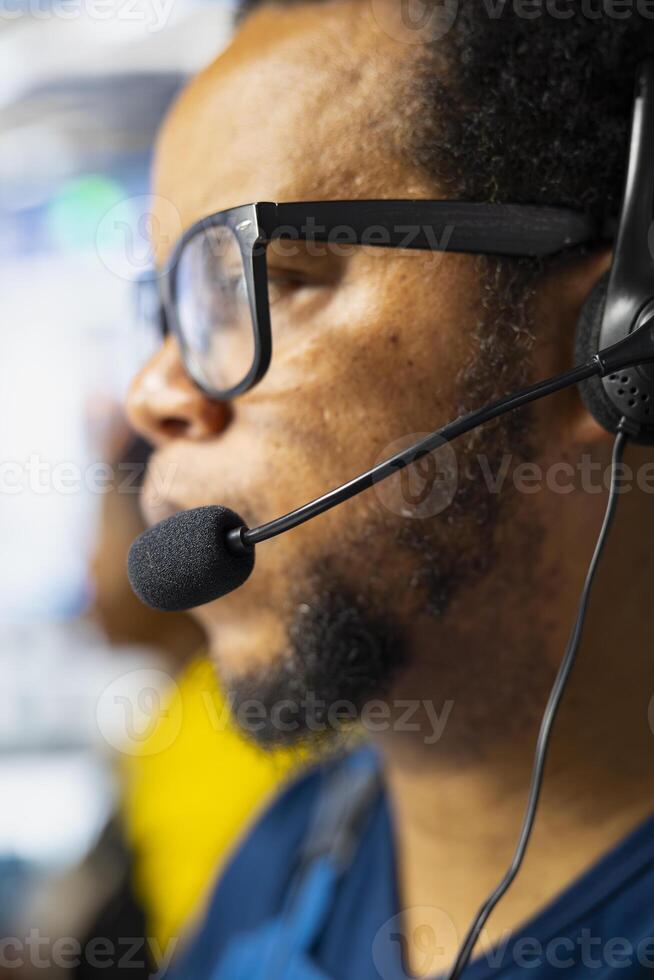 Solar energy male supervisor offering remote support in high tech factory, working in customer service call center. Operator sales representative gives assistance, industrial facility. photo