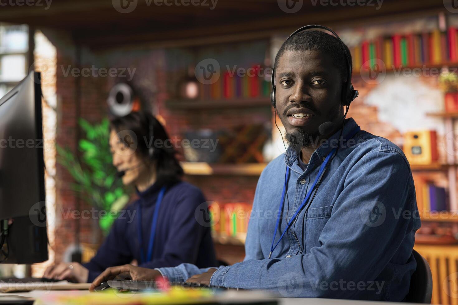 Portrait of call center tech engineer using remote access tools to connect to customer devices remotely for troubleshooting. Customer center employee assisting users with updating software photo