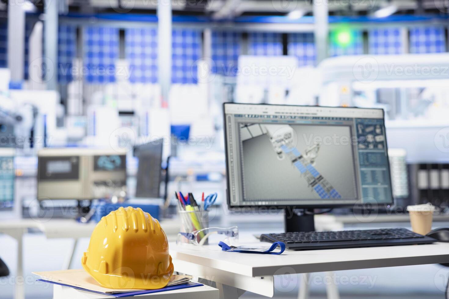 CAD program on PC display in photovoltaics factory used for designing production lines. Simulation software on computer monitor in empty solar panels plant next to yellow hardhat photo