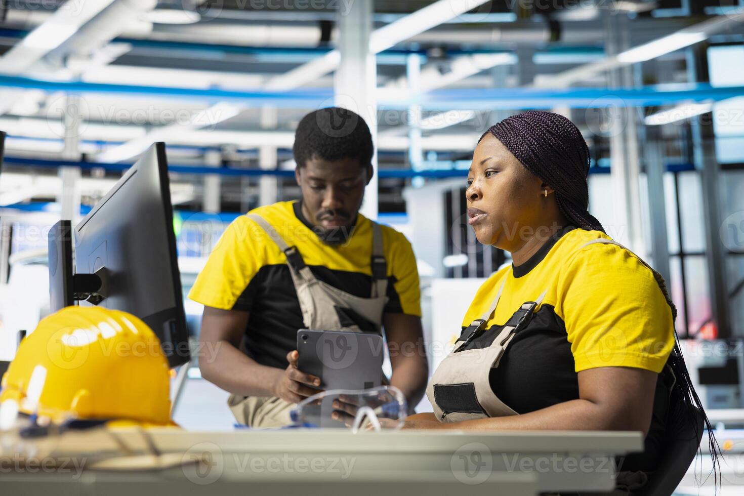 Photovoltaics factory supervisors evaluating performance of robot arms placing solar panels on assembly lines, producing sustainable energy. All black team looking at the production process. photo
