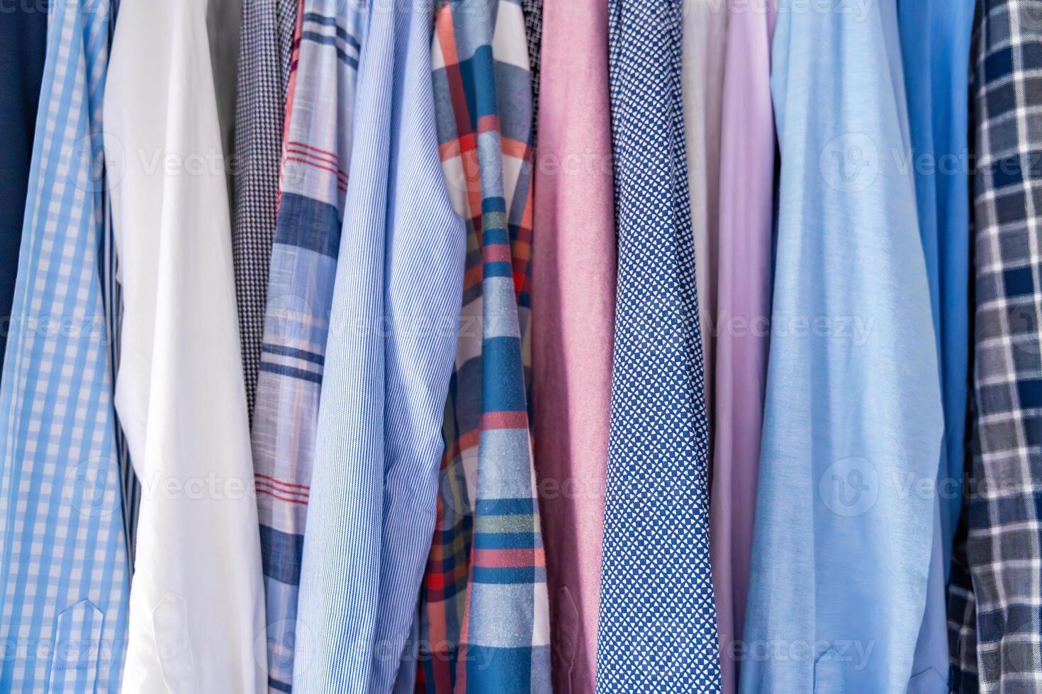 Close-up of various men shirts showing different fabrics, textures and colors. Concept of textile variety, material quality and male clothing style. High quality photo