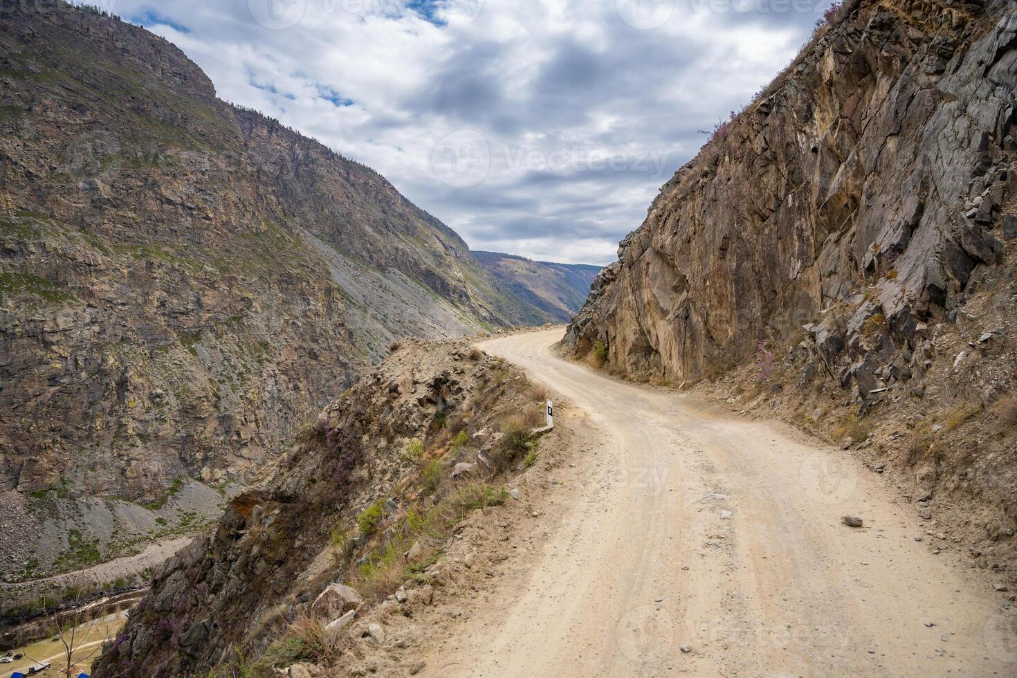 Gravel road winding through Katu Yaryk pass in Altai mountains Russia Mountain route connecting remote valley with highland plateau. High quality photo