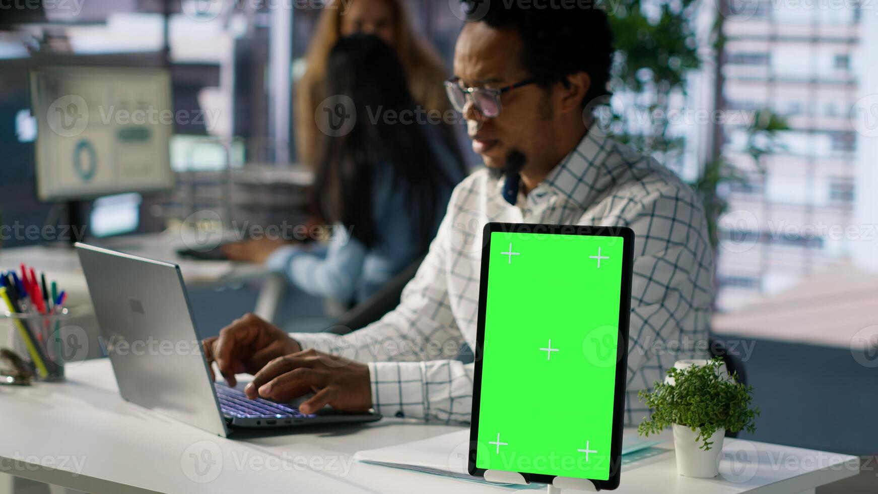 Professional executive analyzing monthly reports next to chroma key display, working on strategy planning and financial forecasts. Business developer looking into data for decision making. Camera A. photo