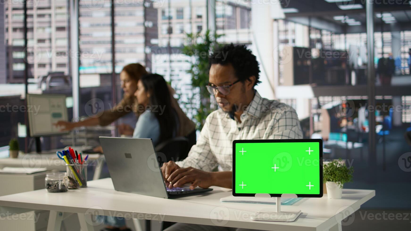 Executive assistant working on document preparation with green screen at his desk, planning business strategy for company development. Achieving organizational goals. Camera B. photo