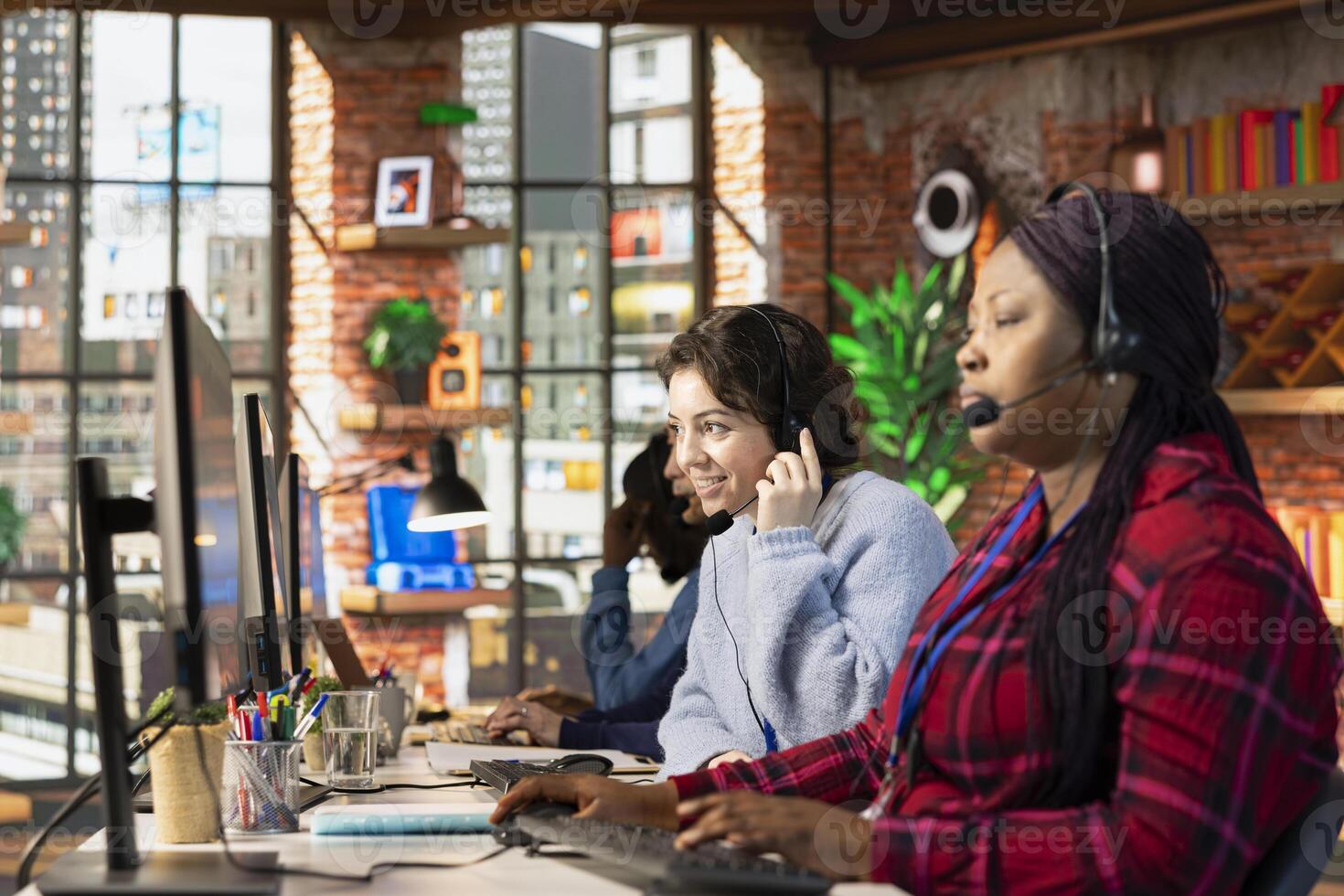 Friendly customer service employee tracking support ticket in dedicated company software on computer. Upbeat call center agent at office desk creating support ticket for customer calling photo
