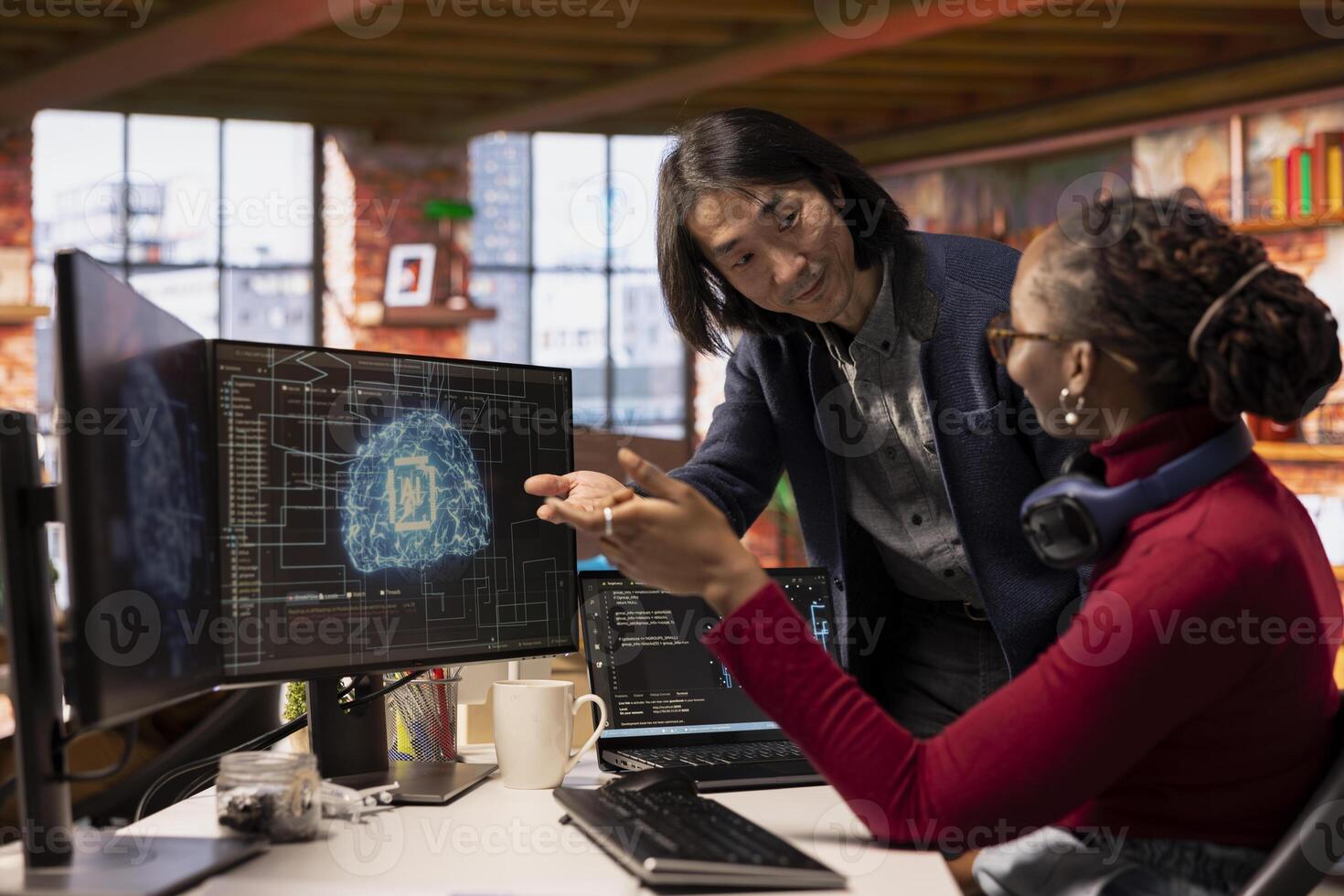 CTO manager in multiethnic startup office helps technician coding advanced AI algorithm and machine learning models. Team leader overseeing work done by employee in Silicon Valley workplace photo